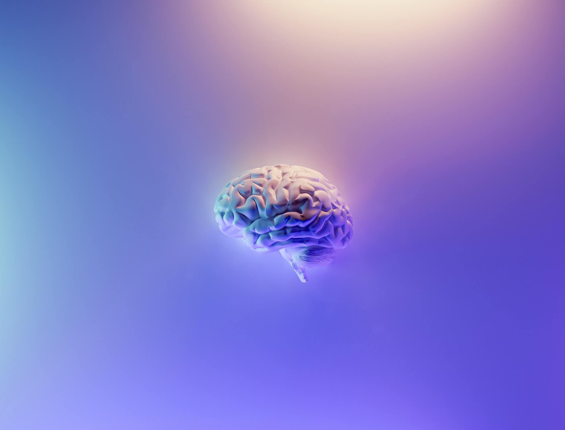 Ilustração de um cérebro tridimensional flutuando sobre fundo com gradiente em tons de roxo e azul