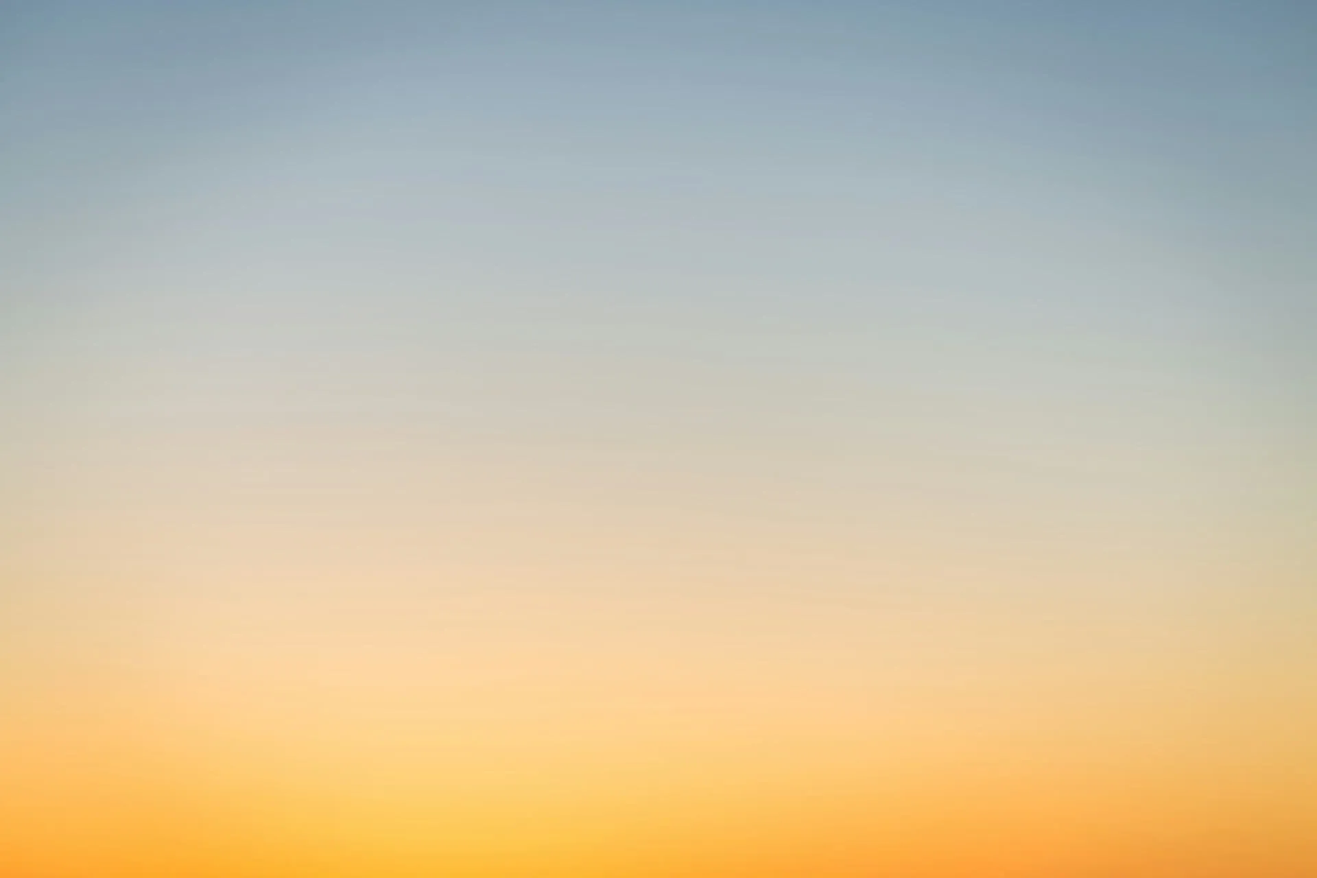 Gradient sky background transitioning from warm orange horizon to cool pale blue above