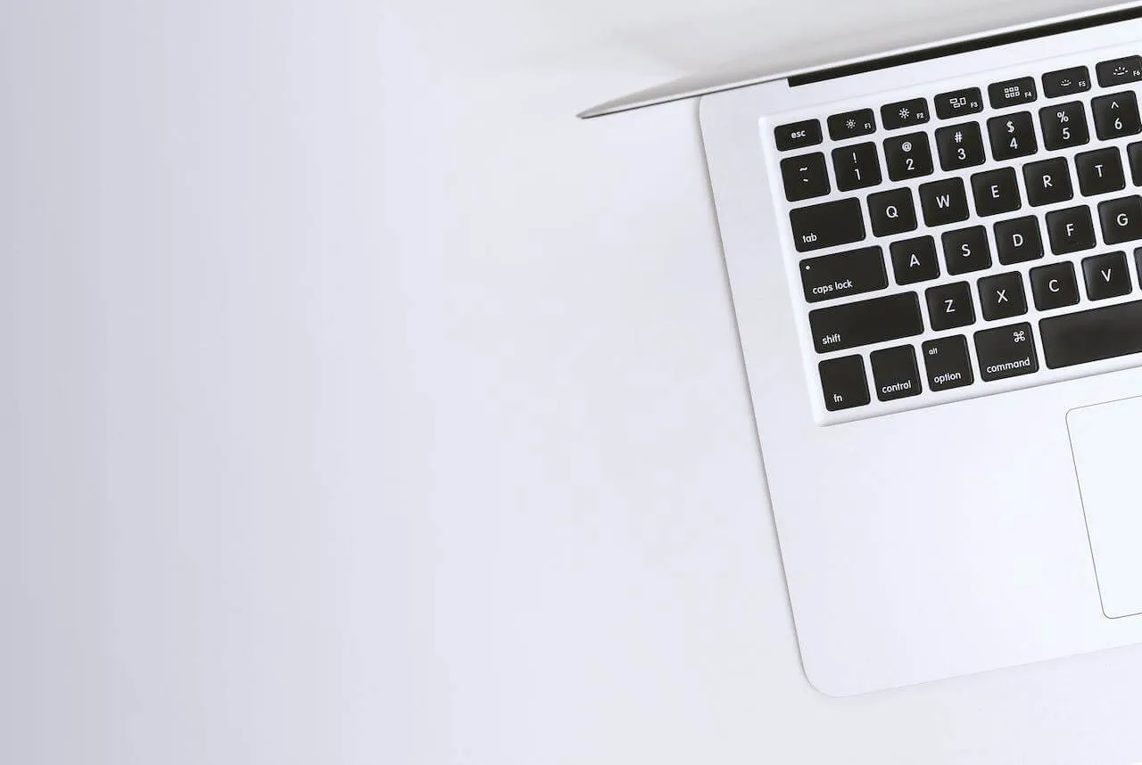 angled top right view of a silver laptop keyboard on clean white surface