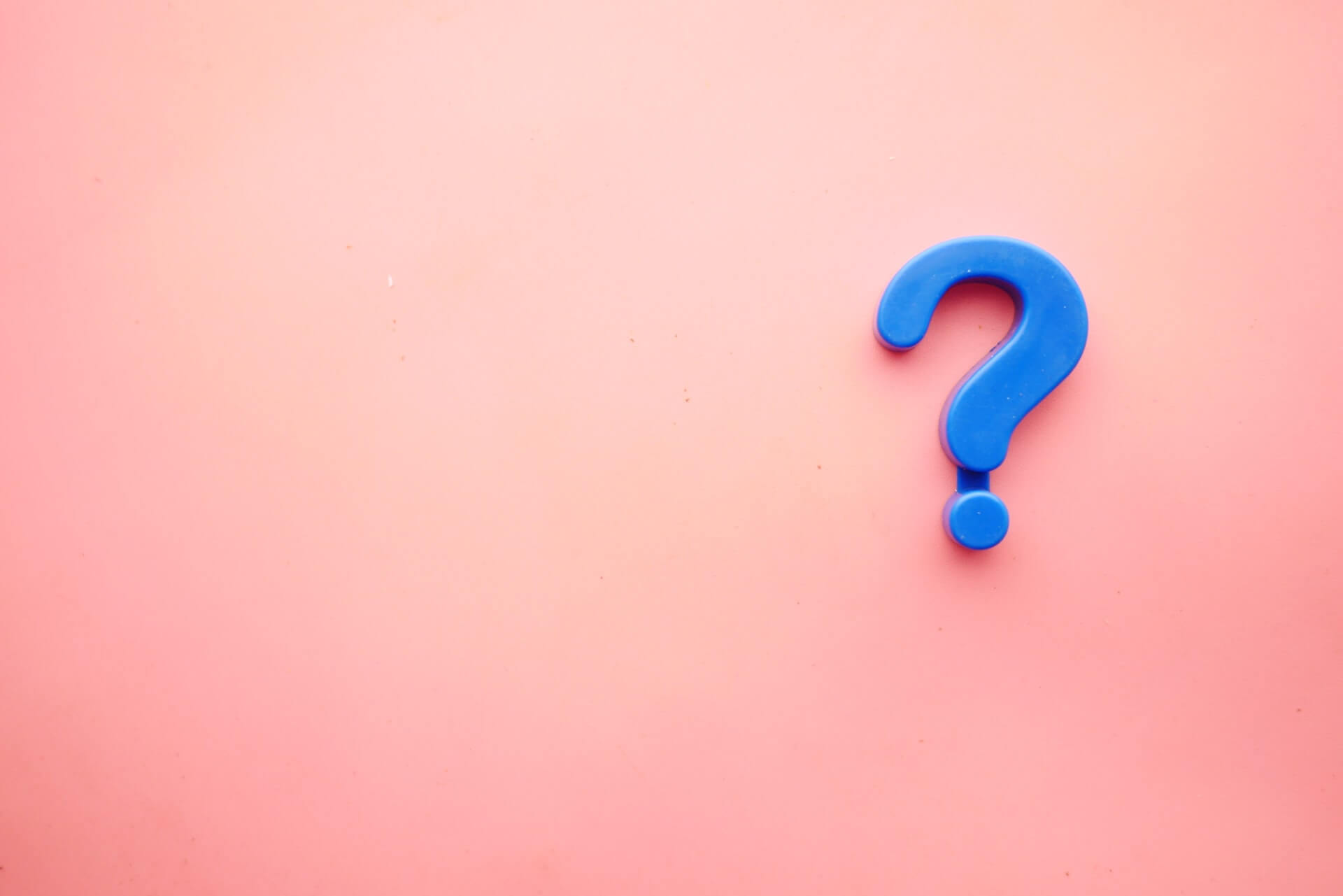 Three-dimensional blue question mark on a solid pink background, illustrating questions and highlighting the FAQ nature of the Coverflex blog post