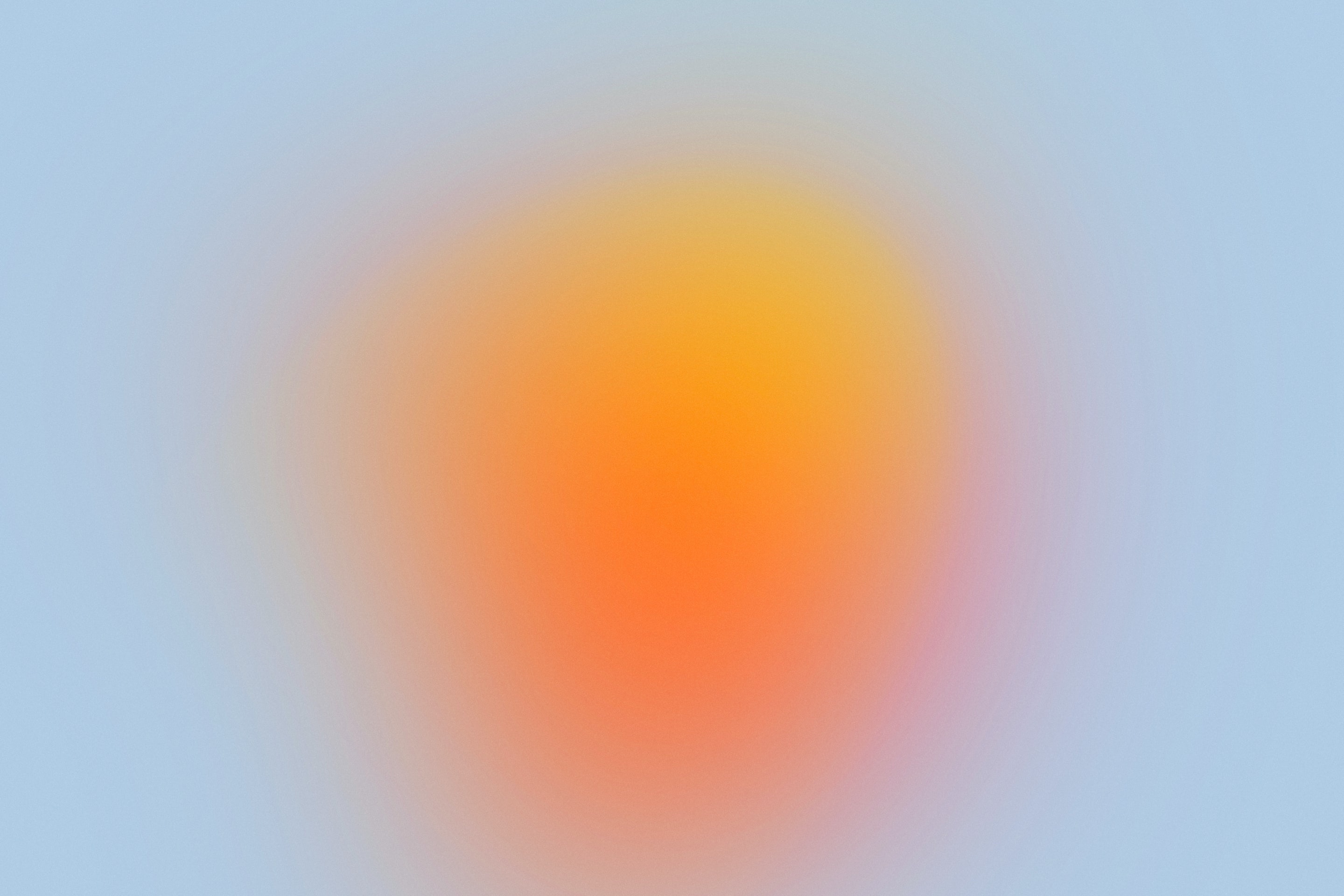 Abstract blurred circular gradient blending orange pink and yellow at center on pale blue backdrop