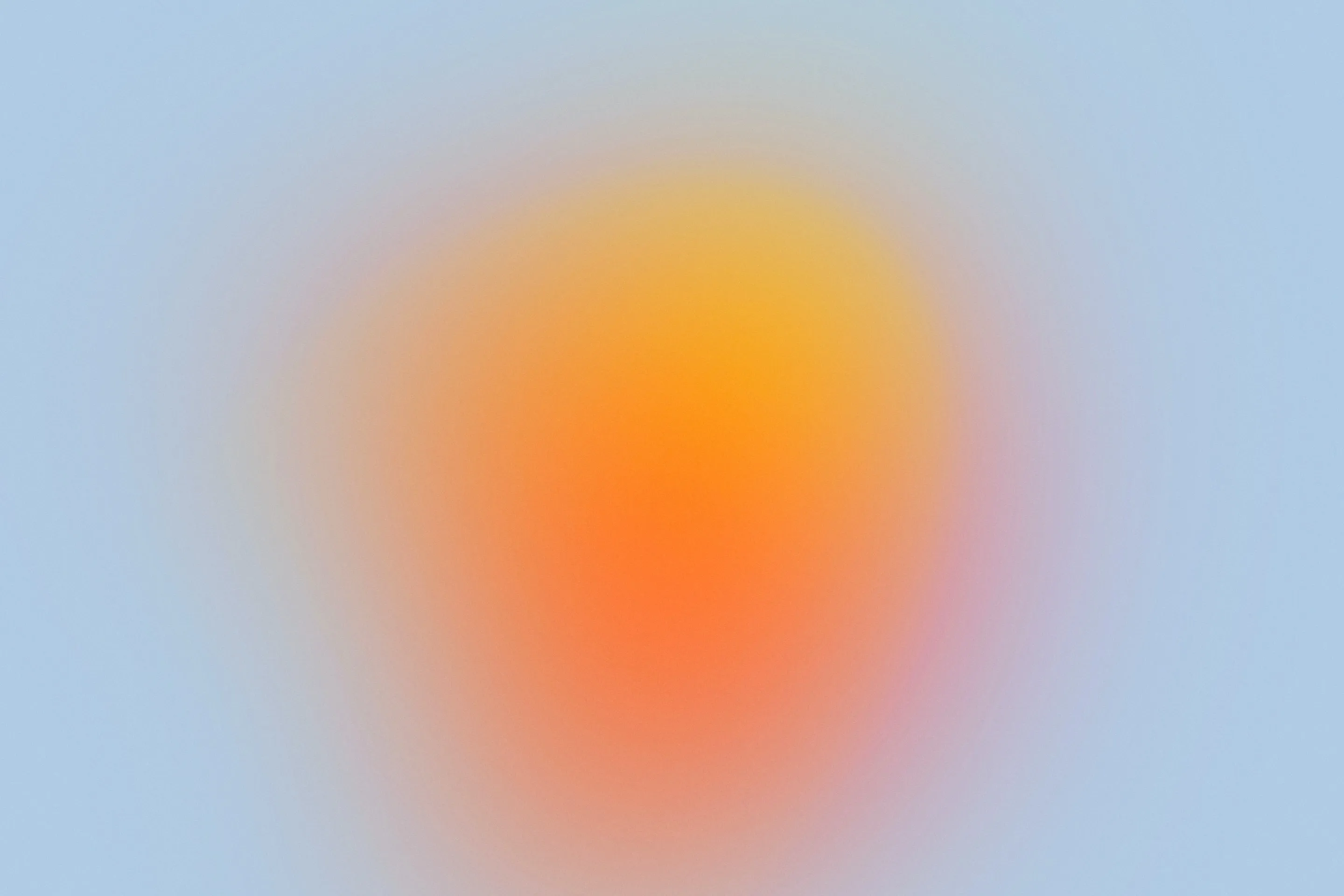 Abstract blurred circular gradient blending orange pink and yellow at center on pale blue backdrop