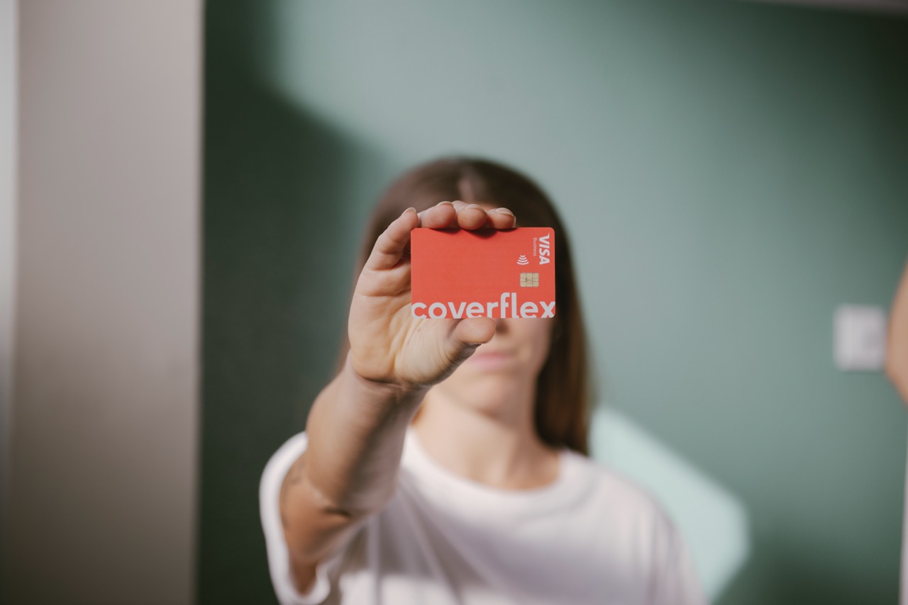 Persona sujeta frente a la cámara tarjeta roja Coverflex con logo Visa